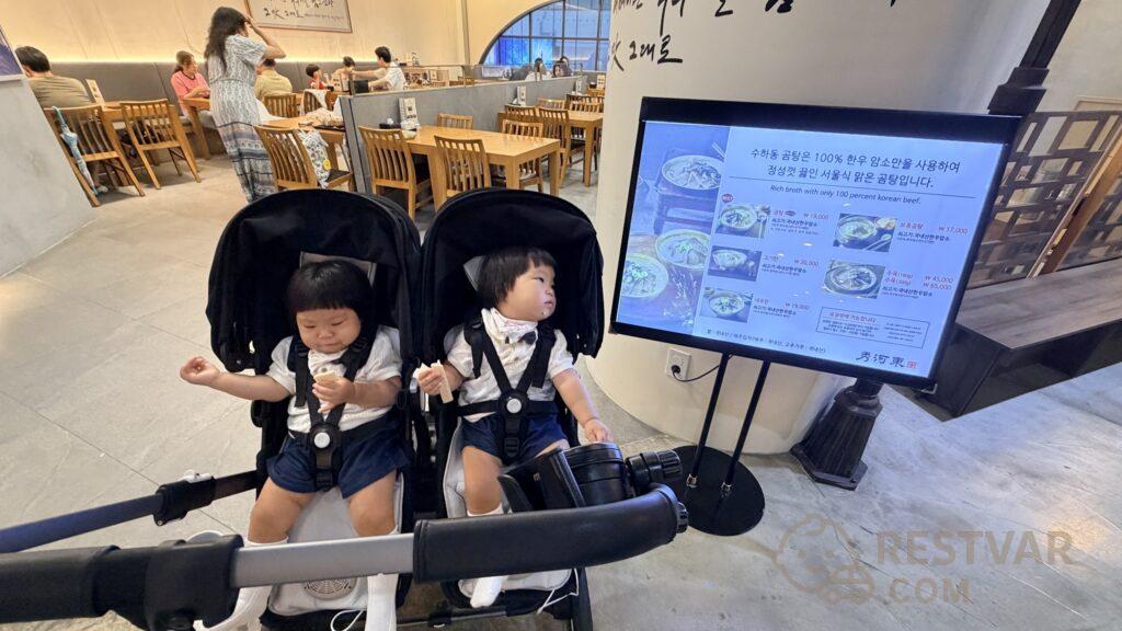 롯데월드몰 6층 식당에서 유아용 의자에 앉은 아기와 메뉴 안내판