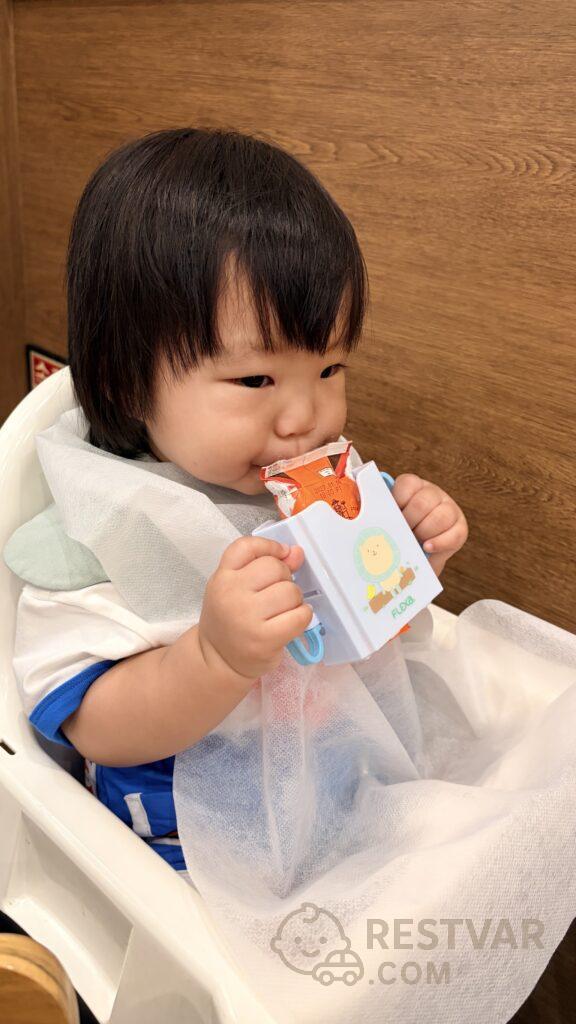 우유팩 홀더에 끼운 멸균우유를 두 손으로 잡고 마시는 16개월 아기